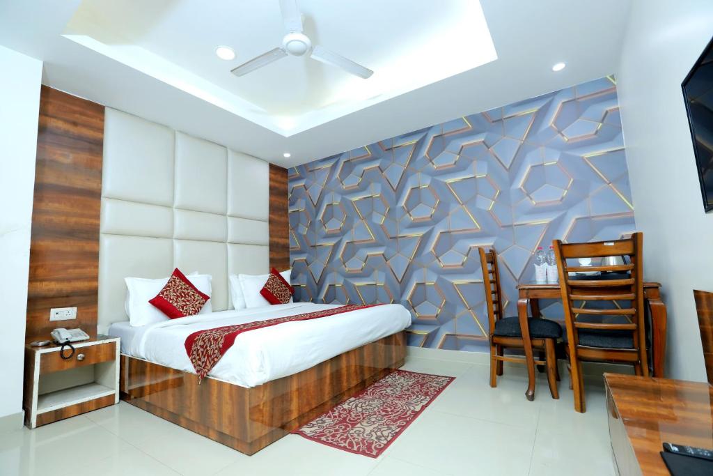 a bedroom with a bed and a desk and a chair at Hotel Mars Meg at Delhi Airport in New Delhi