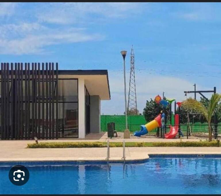 una piscina con parque infantil y un tobogán en Dpto. coto privado con alberca en Mazatlán