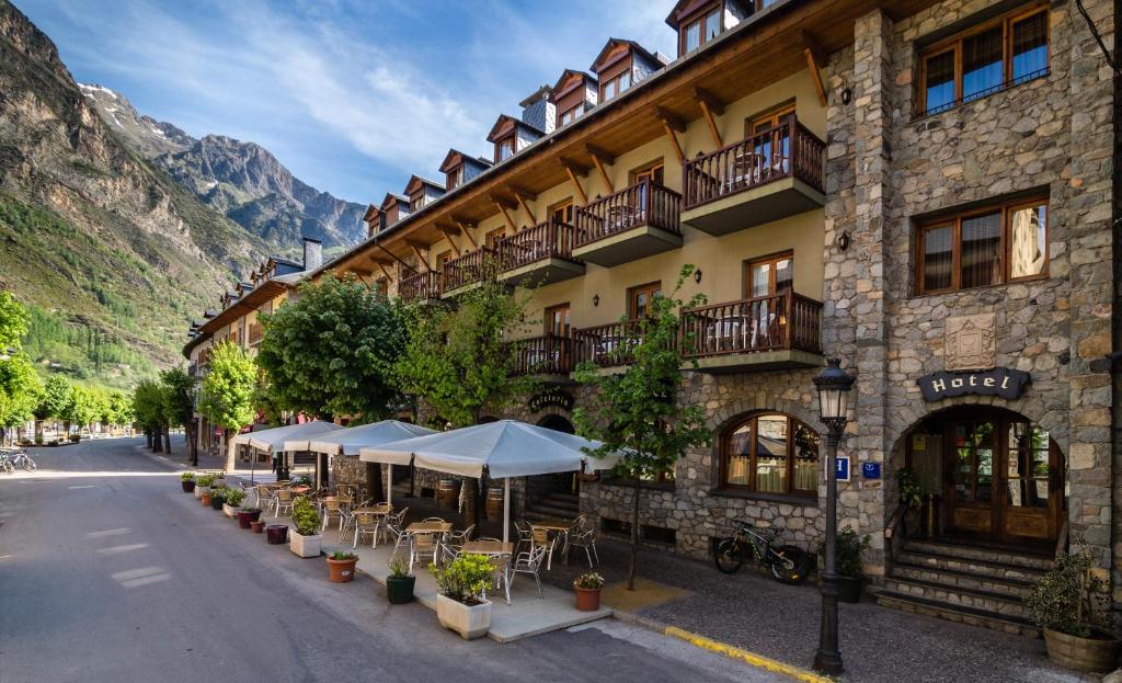 a building with tables and chairs in front of it at Hotel Ciria in Benasque