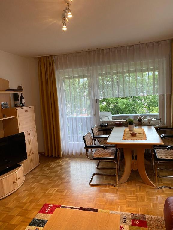 ein Wohnzimmer mit Tisch und Stühlen und einem Fernseher in der Unterkunft Wohnung mit Bergblick in Mittenwald in Mittenwald