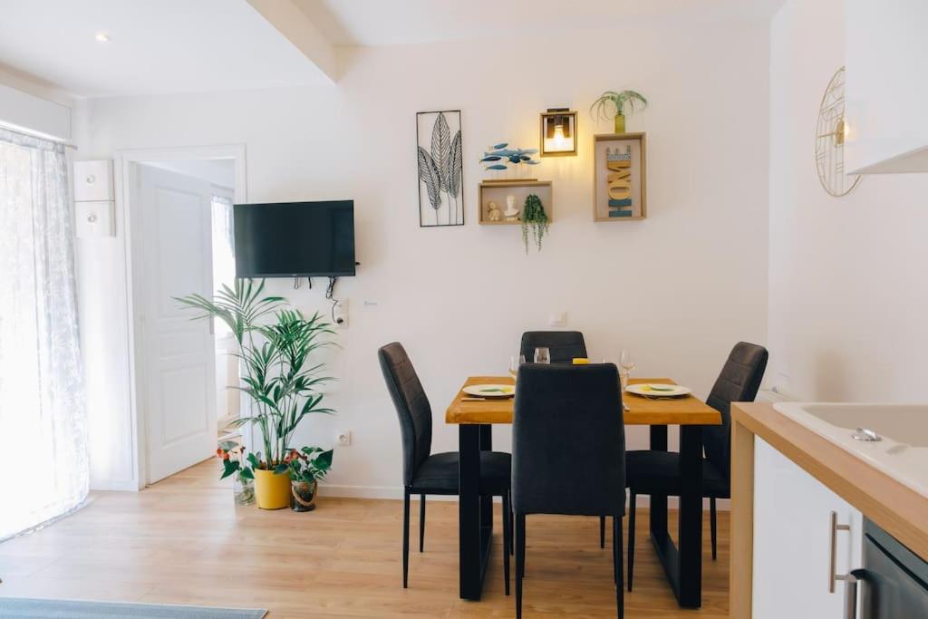kuchnia i jadalnia ze stołem i krzesłami w obiekcie Appartement avec jardin w mieście Bègles