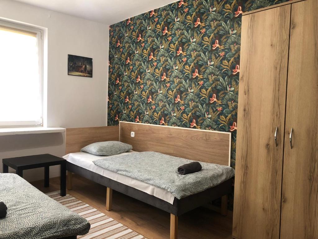 a bedroom with a bed and a wallpaper with flowers at Noclegi na Sudeckim in Świebodzice