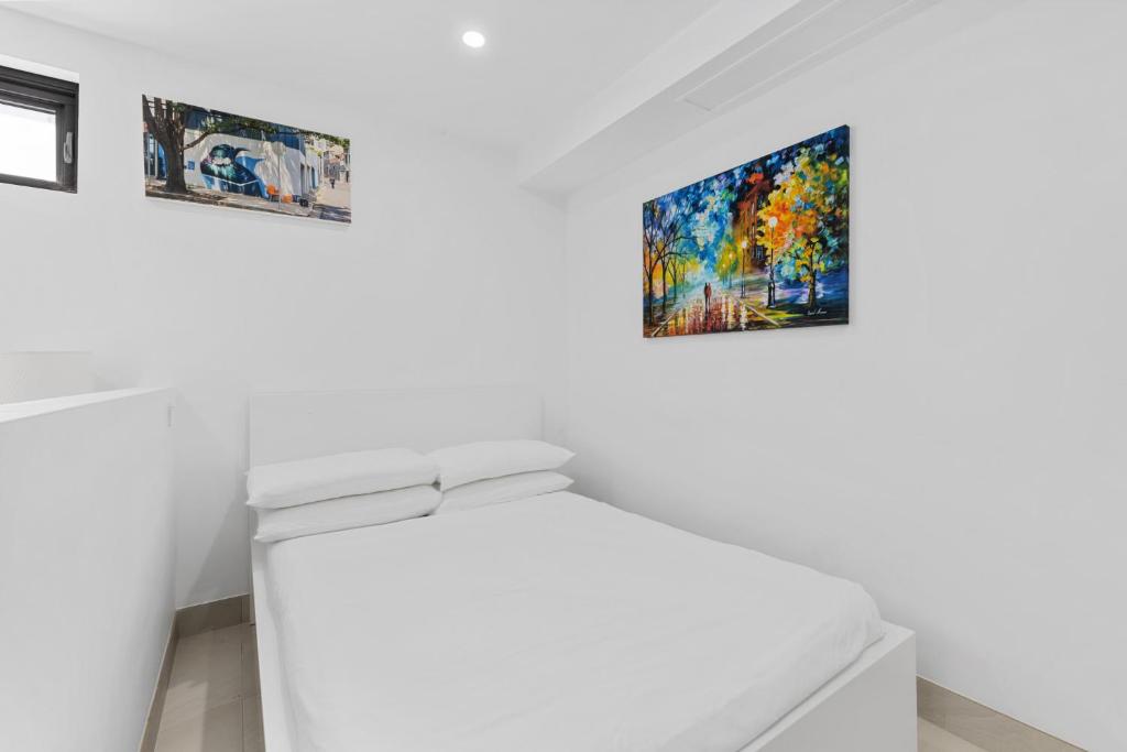 a white room with three pictures on the wall at Bright Studio Apartment in Surry Hills' Heart in Sydney