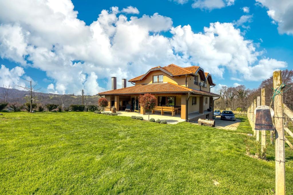 a yellow house with a grassy yard at Hedonistic Vineyard Estate With Hot Tub - Happy Rentals in Ludbreg