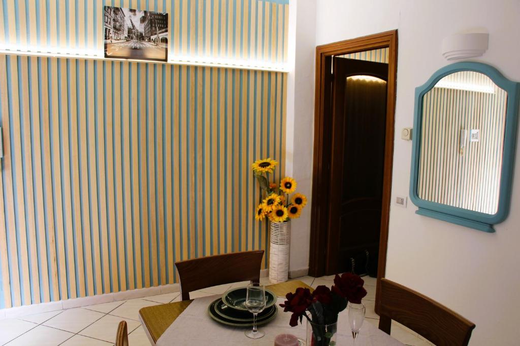 ein Esszimmer mit einem Tisch und einer Vase aus Blumen in der Unterkunft Appartamento centrale in Tortona