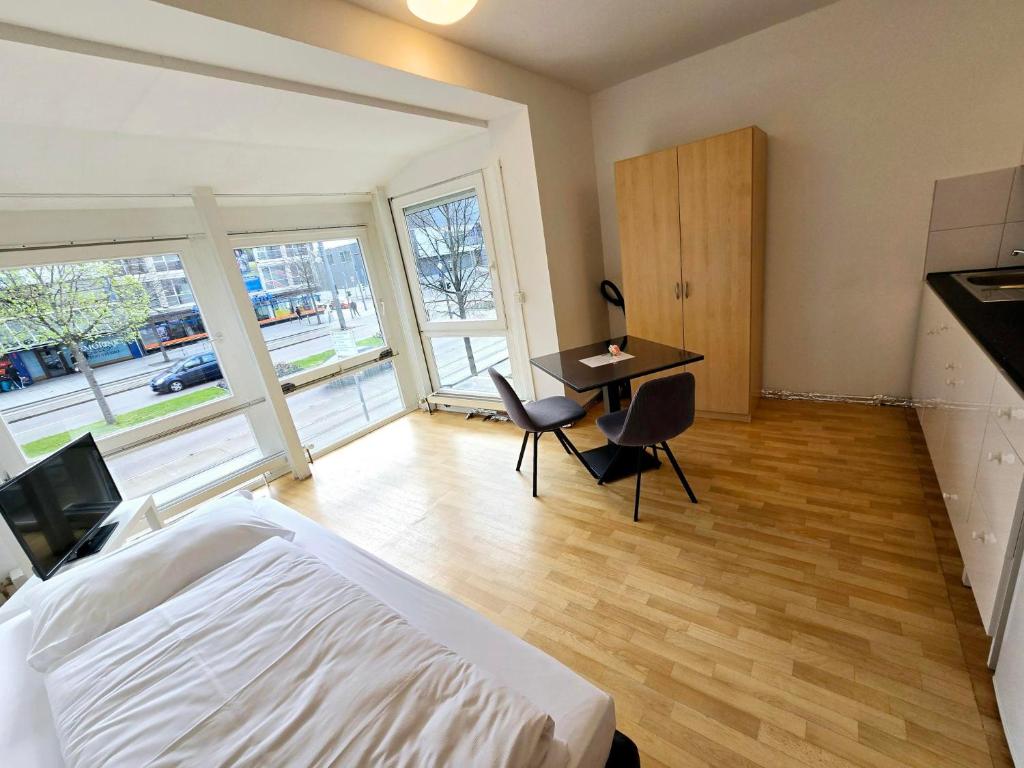 a bedroom with a bed and a desk with chairs at Apartments EFDE GmbH in Heilbronn