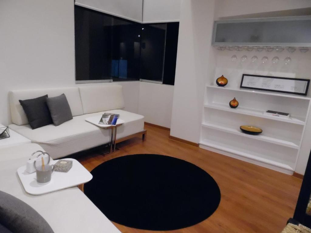 sala de estar con sofá blanco y alfombra negra en Puruma Apartment, en Lima