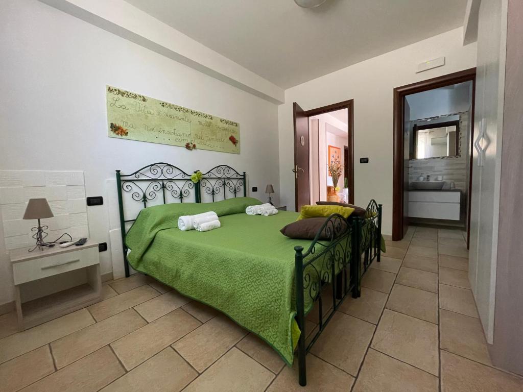 um quarto com uma cama verde num quarto em B&B Francesca em Scorrano
