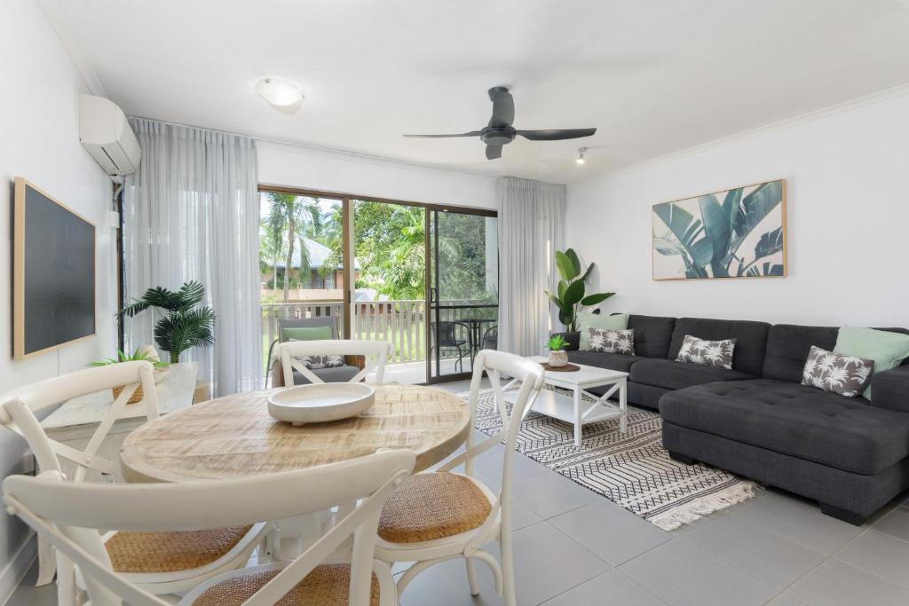 a living room with a table and a couch at Unit 4 @ Tropical Reef Apartments in Port Douglas