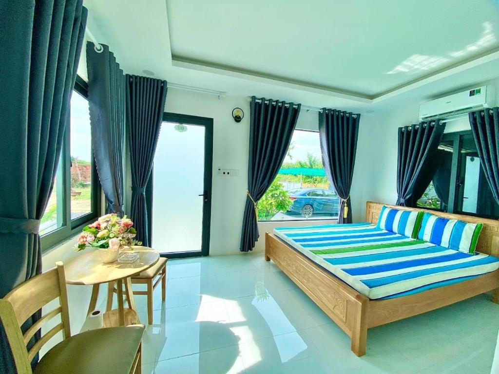 1 dormitorio con 1 cama, mesa y sillas en Hotel Cù Lao 3 (TiTi), en Tây Ninh