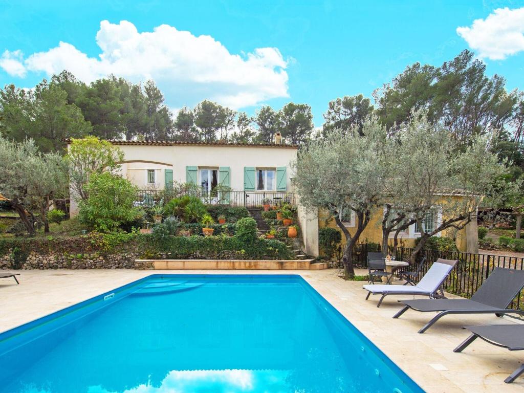 une piscine avec des chaises et une maison en arrière-plan dans l'établissement Villa in Provence with Pool and Charm, à Draguignan