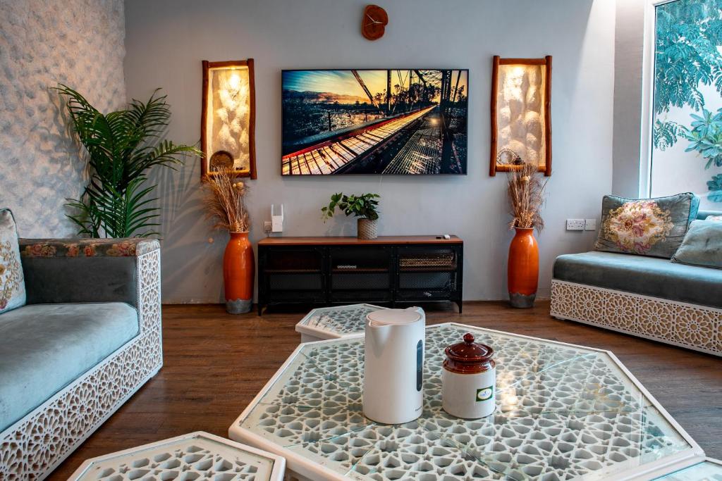 uma sala de estar com dois sofás e uma mesa em Elegant Garden & 2Living Areas, 2 Bed Rooms for 6 Guests em Umm al ‘Amad