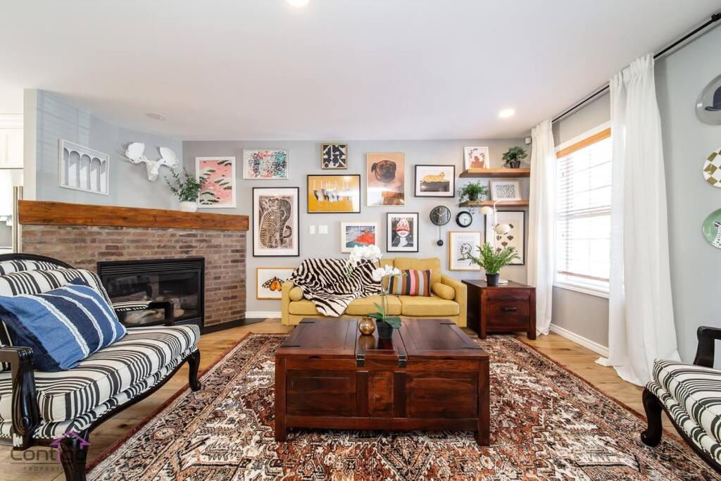 a living room with a couch and a fireplace at Stylish Euro Vibes Home, Small Gym, AC, Yard, Office in Edmonton