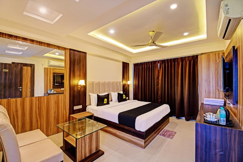 um quarto de hotel com uma cama e um sofá em OYO Palette - The Grand Aryans Hotel em Calcutá