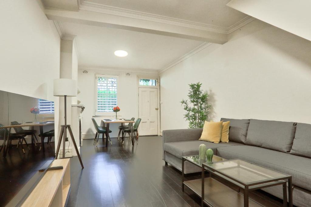 uma sala de estar com um sofá e uma mesa em Spacious 3 Bedroom House Glebe with 2 E-Bikes Included em Sydney