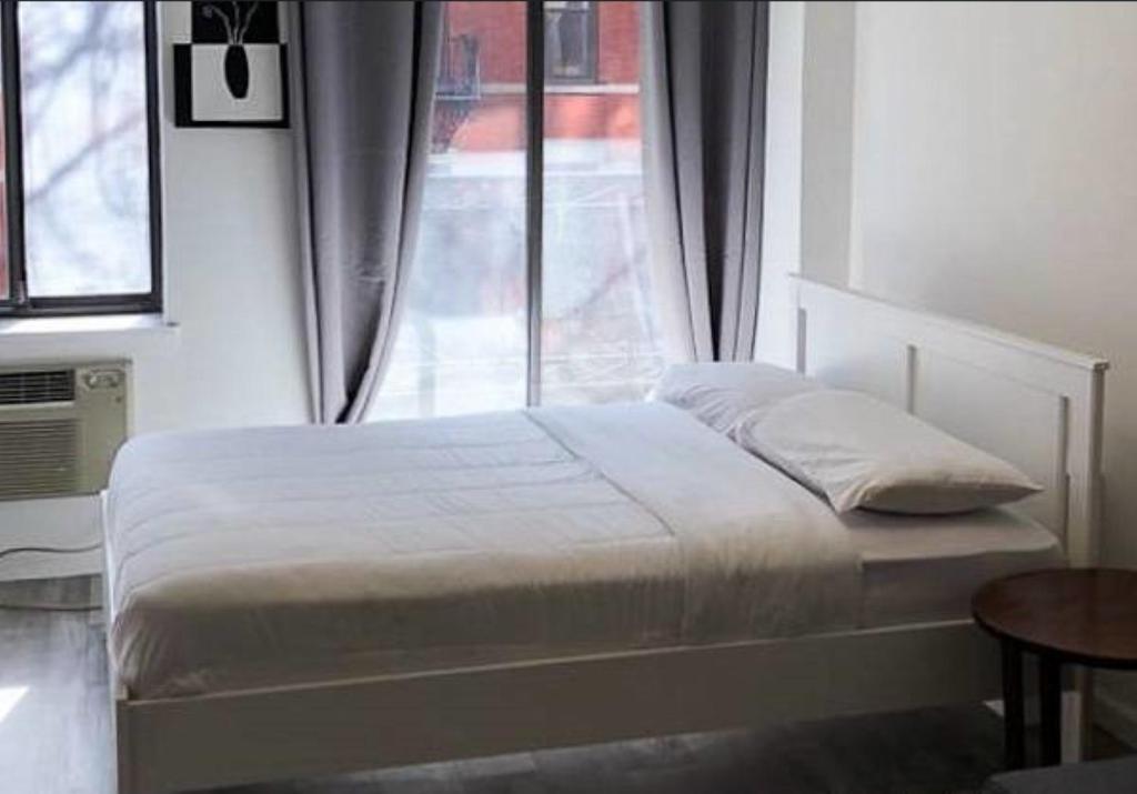 Bett in einem Zimmer mit Fenster in der Unterkunft Cozy Studio! Upper East Side! in New York