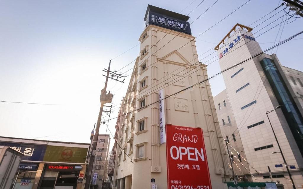 a tall building with a sign in front of it at The First Boutique Hotel in Gwangju