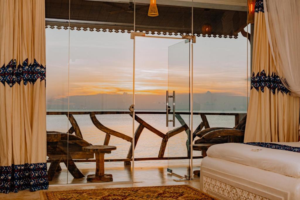 una camera con una grande finestra con vista sull'oceano di Royal Cliff Zanzibar a Zanzibar City