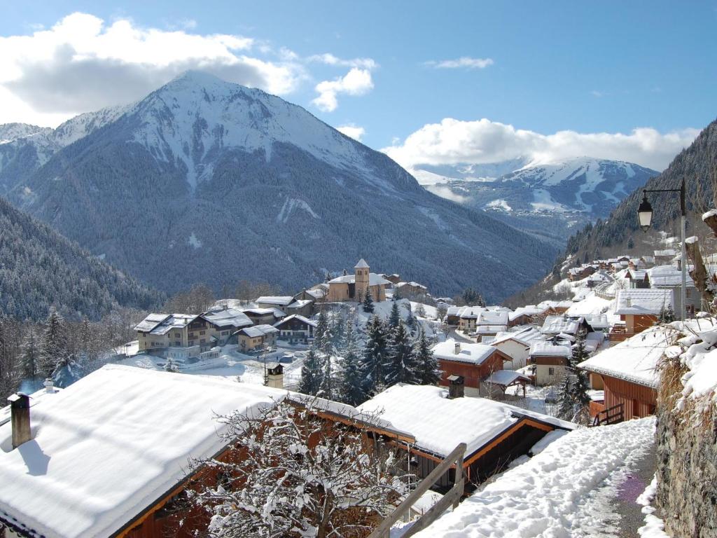 a village covered in snow with a mountain in the background at Spacious holiday home near center of Champagny in Le Villard