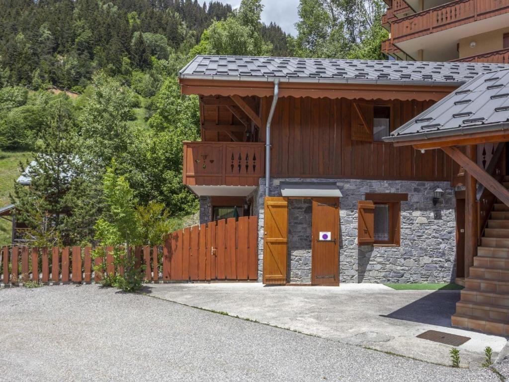 a house with a wooden gate and a fence at Spacious holiday home near center of Champagny in Le Villard