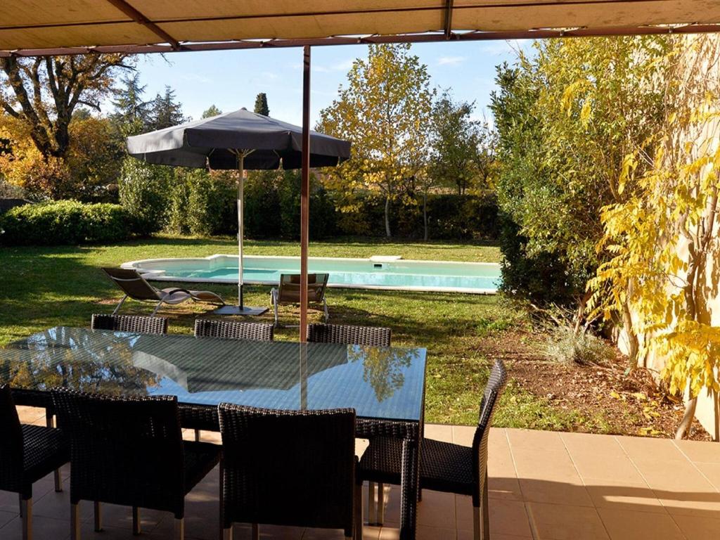 un tavolo con ombrellone accanto a una piscina di Luxury Provencal villa with view on the Luberon surroundings a Saint-Saturnin-lès-Apt