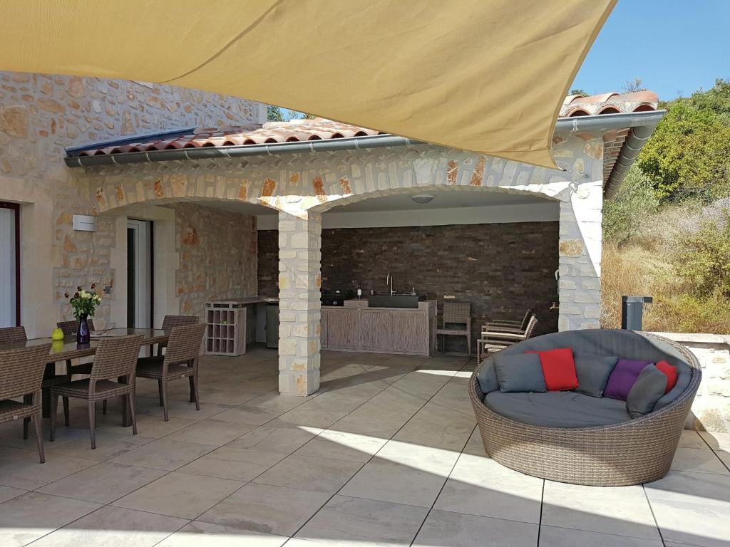 a patio with a table and chairs and an umbrella at Magnificent Villa in Saint Ambroix with Private Pool in Saint-Ambroix