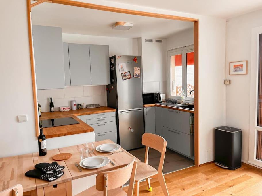 a kitchen with a table and a kitchen with a refrigerator at Appartement tout confort avec vue in Saint-Denis