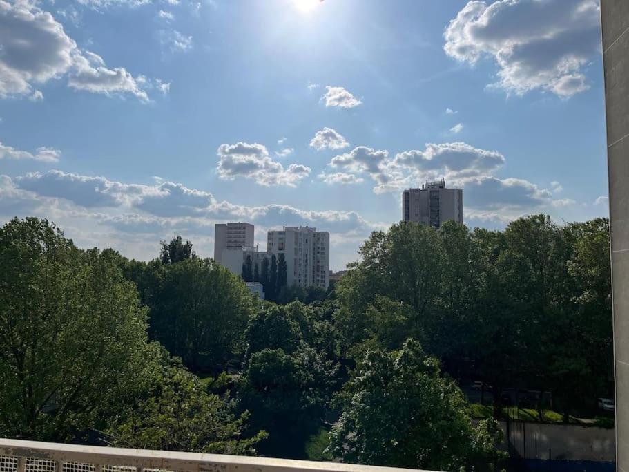 a view of a city with trees and buildings at Appartement tout confort avec vue in Saint-Denis