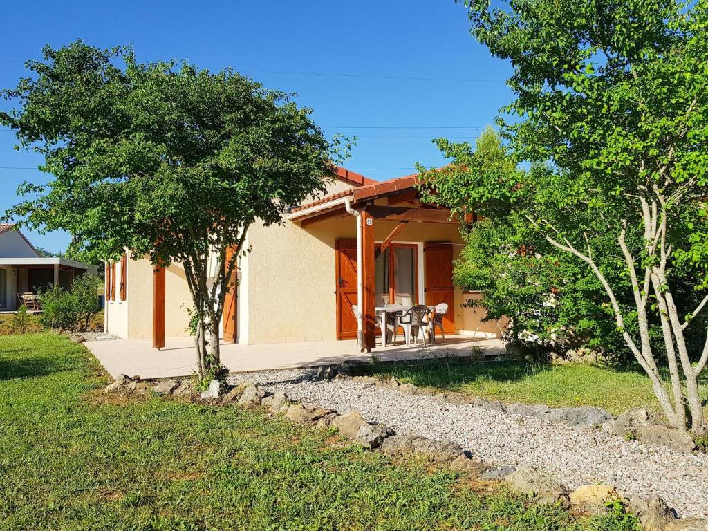 een klein huis met een patio en bomen bij Vayamundo L'Espinet in Quillan
