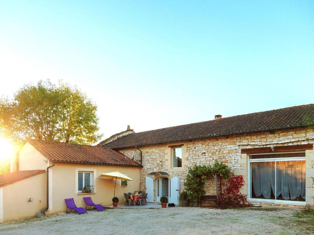 a brick house with purple chairs and a patio at Family Stay in Scenic Cazals in Cazals