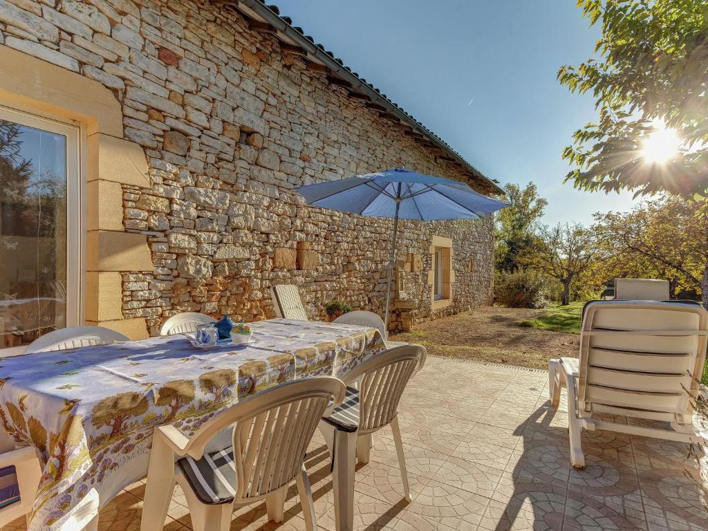 a table and chairs with an umbrella on a patio at Amazing Holiday Home in Cazals with Terrace in Cazals