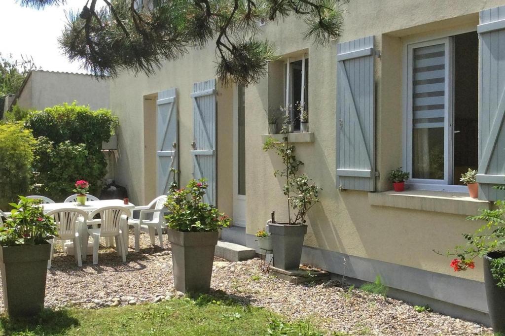ein Haus mit einem Tisch und Stühlen im Hof in der Unterkunft Holiday flat Cayeux-sur-Mer - NMD05008-P in Cayeux-sur-Mer