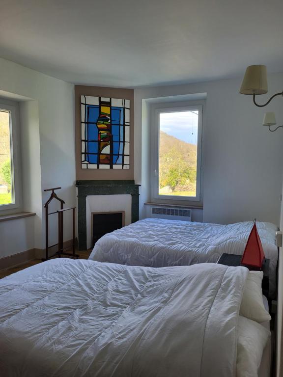ein Schlafzimmer mit 2 Betten und einem Buntglasfenster in der Unterkunft Gite de montagne en Ariège 