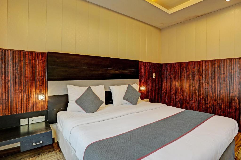 een slaapkamer met een groot bed met een houten hoofdeinde bij Super Townhouse 1242 Tipsyy Inn 16 in Gurgaon
