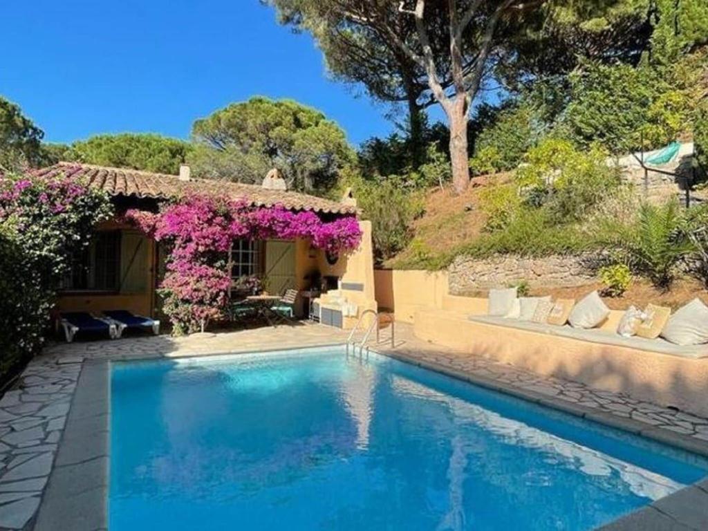 ラ・クロワ・ヴァルメにあるCharming Holiday Home in La Croix-Valmer with Poolの紫の花の家の前のスイミングプール