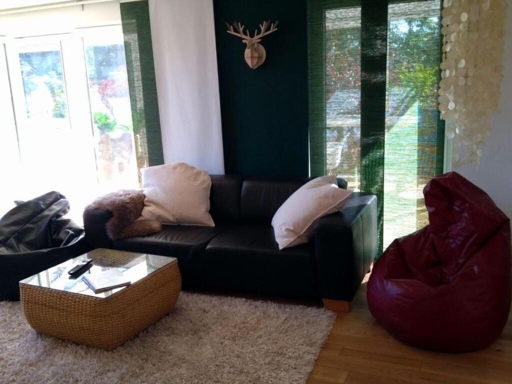 a living room with a black couch and a table at Pine cones in the Haslehaus in Feldberg