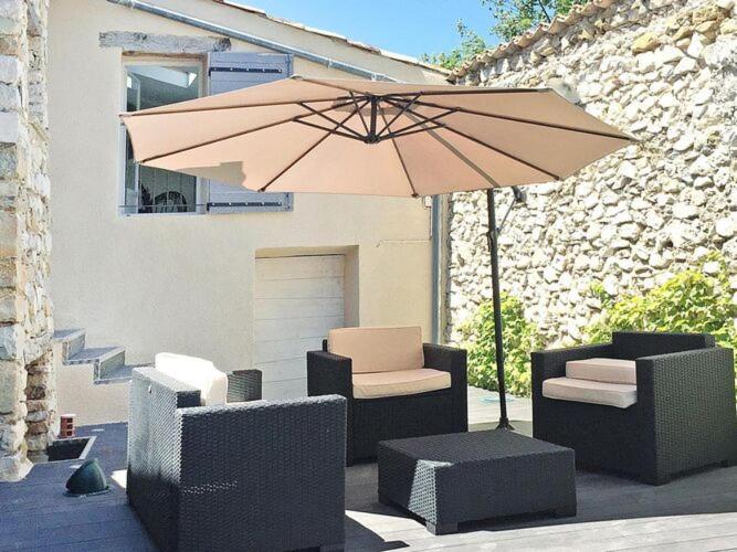 a patio with chairs and an umbrella and a table at Holiday Home Savoillans - PRV01361-F in Savoillan