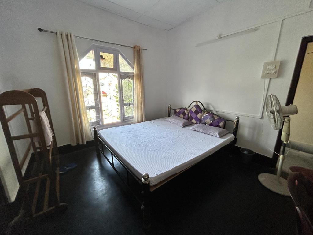 a small room with a bed and a window at Munin's Guest House in Jorhāt