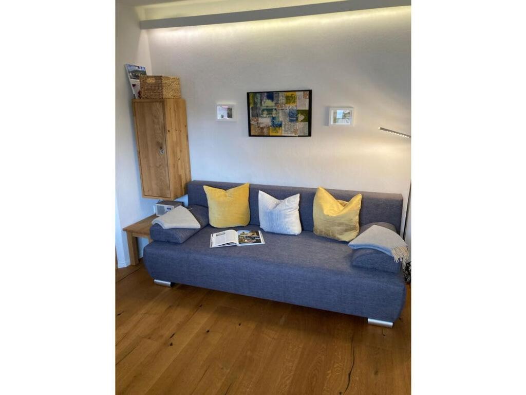 un divano blu con cuscini gialli in soggiorno di Holiday apartment Seimbergblick a Brotterode