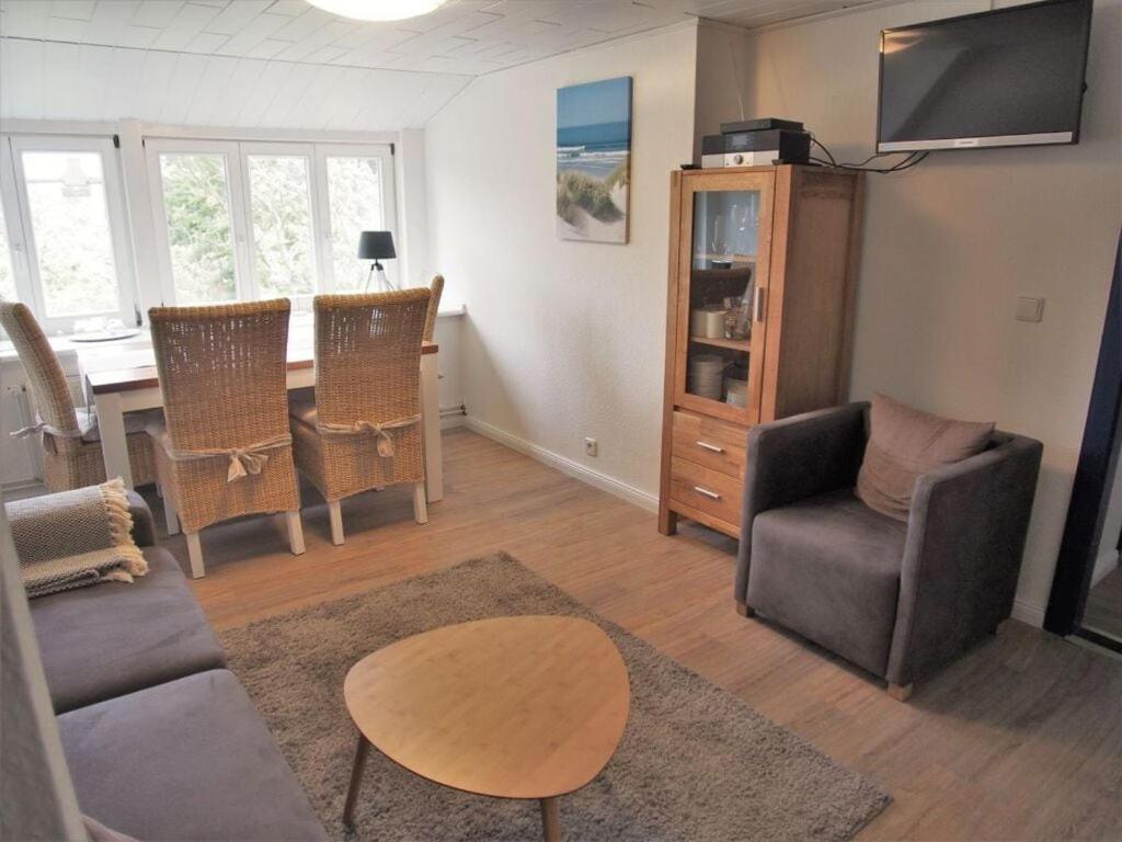 a living room with a table and chairs and a television at Holiday apartment Strandkrabbe in Ockholm