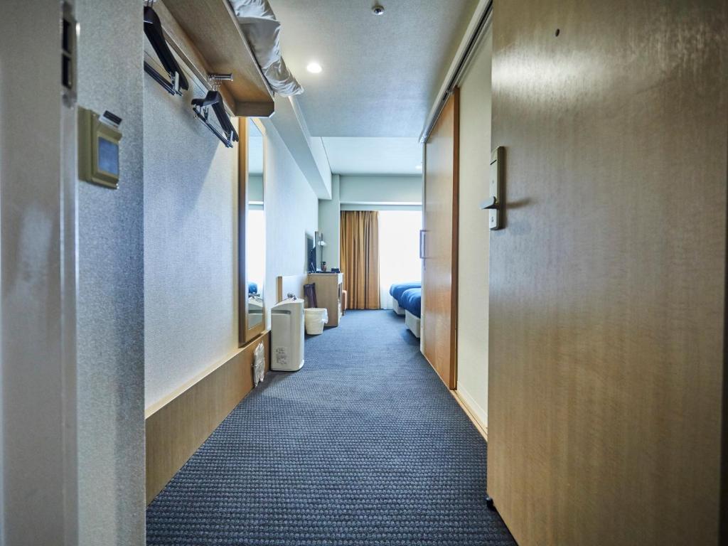 a hallway of a hotel room with a door at Kansai Airport Washington Hotel in Izumi-Sano