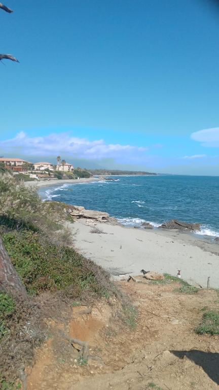 une plage avec l'océan et des maisons au loin dans l'établissement La casa d emma, à Linguizzetta