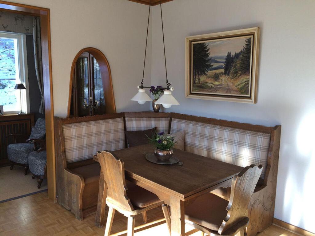 a dining room with a wooden table and chairs at Holiday home Waldhaus am Burbach in Bad Berleburg
