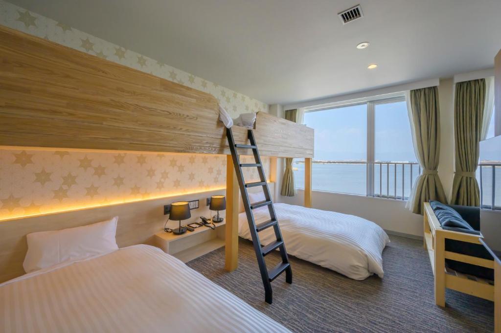una habitación de hotel con 2 camas y una escalera en Kunibiki, en Izumo