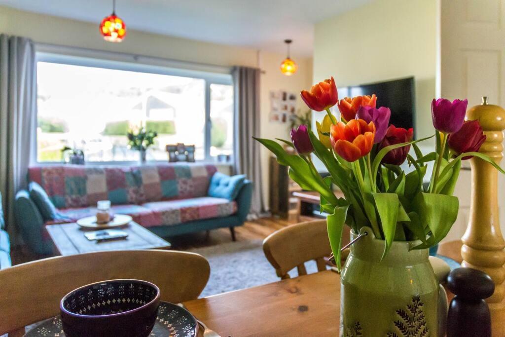 un jarrón de flores sobre una mesa en la sala de estar en Rhianfa Manorbier, en Manorbier