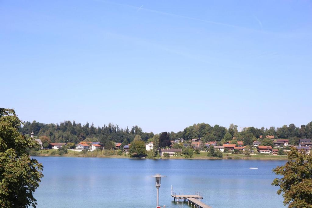 a view of a lake with a dock and houses at Das Bootshaus in Seeon