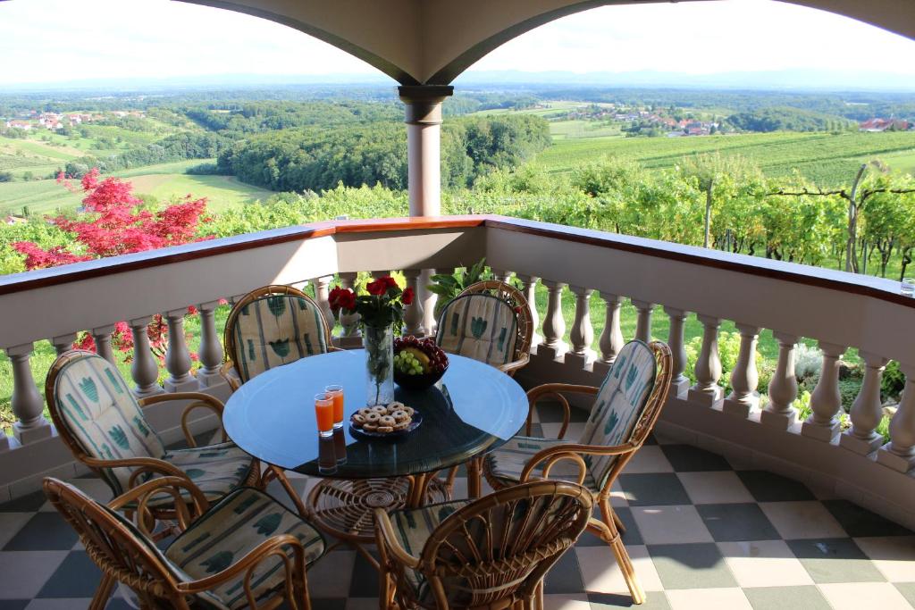 una mesa y sillas en un balcón con vistas en Villa Lotus en Štrigova
