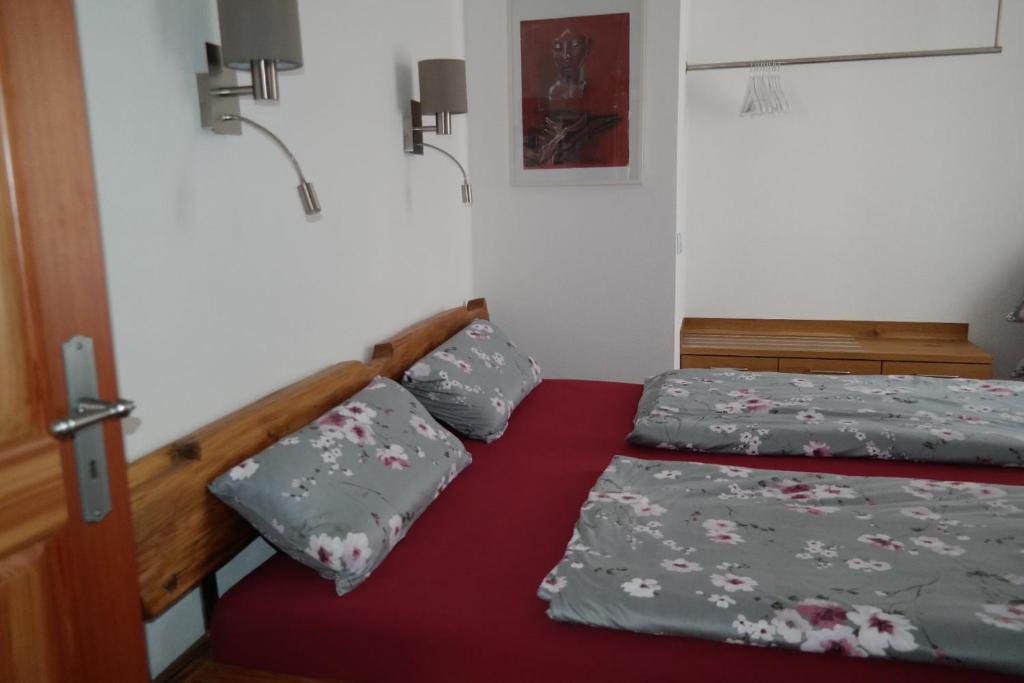 a bedroom with two twin beds and a red bedspread at Ferienwohnung Christine in Strullendorf