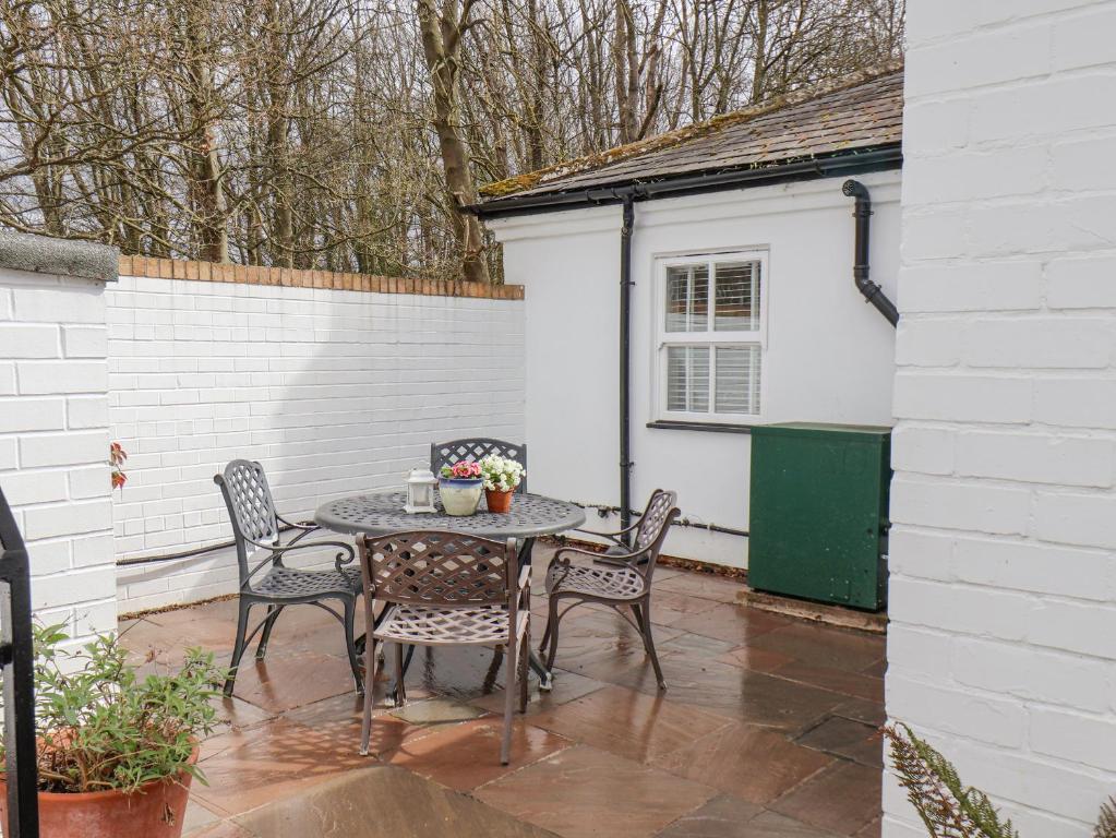 a patio with a table and chairs and a building at Bousdale Cottage in Guisborough