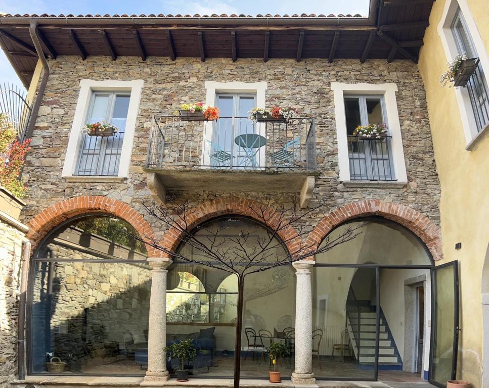 um edifício de pedra com arcos e janelas e uma escadaria em Casa Stella a due passi da Orta em Ameno